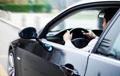 Man driving a car with his arm resting on the window